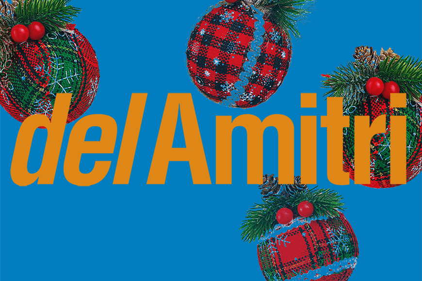 The text 'Del Amitri' over a blue background with red tartan Christmas baubles and Holly