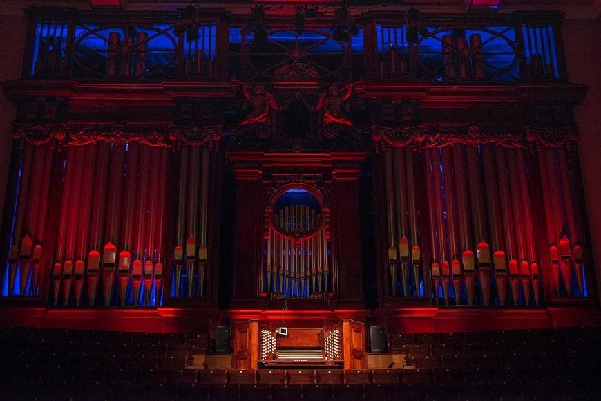 Photograph of the Usher Hall organ lit up in red and blue