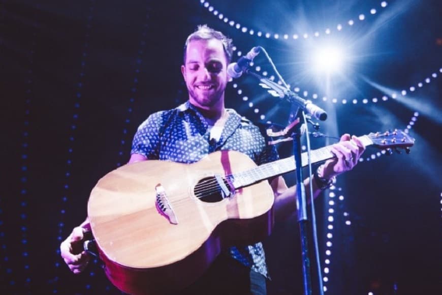 James Morrison smiling on stage with his guitar