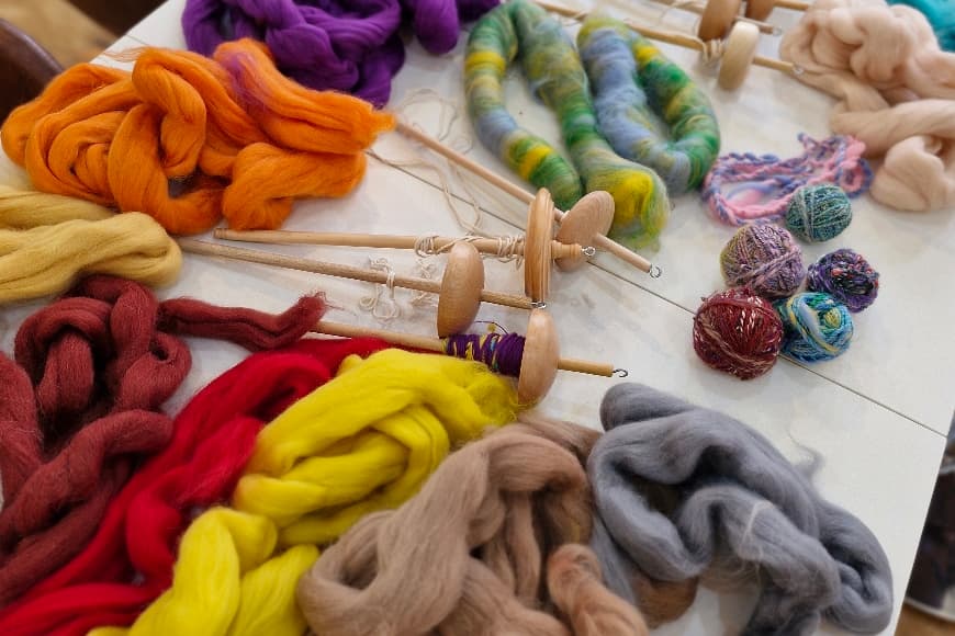 Colourful yarn and wooden spindles on a table
